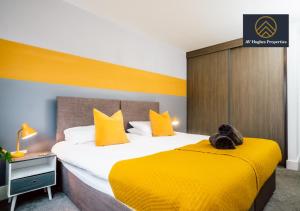 米尔顿凯恩斯Modern One Bedroom Apartment by AV Hughes Properties Short Lets & Serviced Accommodation Milton Keynes - For Couples & Leisure的酒店客房,配有一张带黄色床单的大床