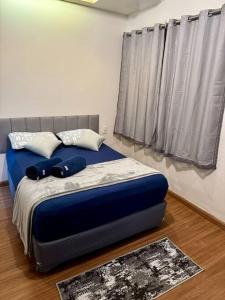 阿拉沙Casa aconchegante em Araxá的卧室内的一张带蓝色床单和枕头的床