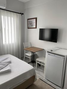 博德鲁姆İZAN VİLLA BAKIŞ APARTMENTS的卧室配有桌子和墙上的电视。