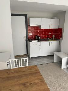 博德鲁姆İZAN VİLLA BAKIŞ APARTMENTS的厨房配有白色橱柜和红砖墙