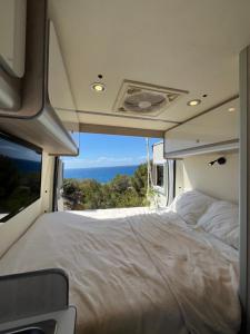 San FranceschBeautiful Campervan (Mallorca)的露营车后面的一张床铺,享有海景