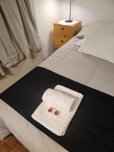 科尔多瓦Hermoso Apartamento en Edificio Saint Michel的一张带毛巾和两个红色按钮的床