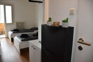 林茨Zentrales Studio-Apartment in Linz, Arbeiter-hit的客房设有两张床和一台黑冰箱。