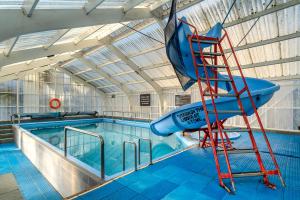 基督城Tasman Holiday Parks - Christchurch的游泳池旁的梯子上的水滑梯