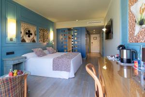 阿德耶阿德里安科隆瓜纳哈尼成人酒店的一间卧室设有蓝色的墙壁和一张带桌子的床