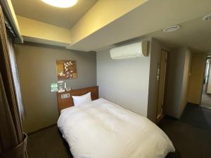 三沢市路由客栈三泽市酒店的卧室配有白色的床
