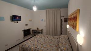 斯特雷萨Guesthouse Serena的卧室配有一张床,墙上配有电视。