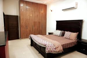 拉合尔Centrally located Villa in the middle of Lahore的一间卧室配有一张床和一个木制衣柜