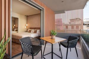 雅典The Residence Christokopidou Hotel & Spa的酒店客房带一张床、一张桌子和椅子