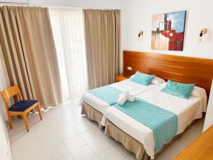 埃尔阿雷纳尔Hotel Selva Arenal的配有一张床和一把椅子的酒店客房