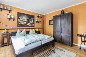 弗伦斯堡Ferienwohnung Kaffeetraum的一间卧室配有一张大床和一个木制橱柜