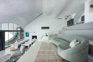 格拉纳达RentitSpain Casa Acantilado的客厅设有绿色沙发和楼梯。