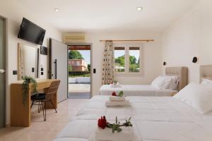 达西亚Santos Apartments & Studios的一间卧室配有两张床、一张桌子和一台电视。