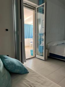 特拉尼B&B Villa Méditerranée con park的一间卧室设有一张床和一个滑动玻璃门