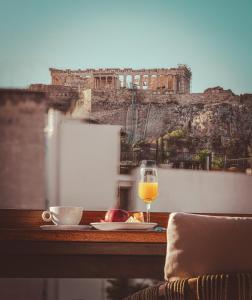 雅典The Residence Christokopidou Hotel & Spa的一张桌子,上面放着一杯葡萄酒和一盘食物