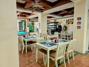 芭东海滩Patong Central Residence and Apartment的一个带桌椅的用餐室和一个游泳池
