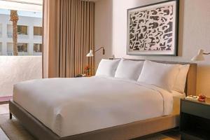 斯科茨The Monarch的一张大白色的床,位于酒店客房内