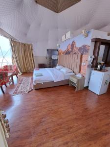 瓦迪拉姆Hasan Zawaideh Camp的卧室配有一张挂有山壁画的床。