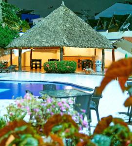 比亚维森西奥Hotel Maria Gloria的一个带游泳池和茅草小屋的度假村