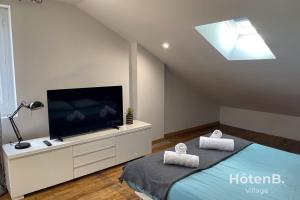 里摩日Large house close to city center Limoges的一间卧室设有平面电视和一张床。