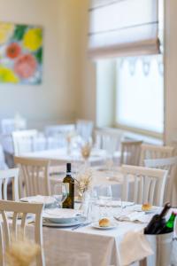 索伦托旅游酒店的用餐室配有白色的桌子和白色的椅子