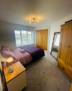 切森特Whiteclouds的一间卧室配有一张紫色的床和一个木制橱柜