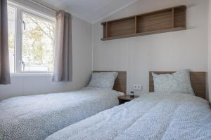 金洛伊Vakantiehuis Hoge Kempen - 25 minuten Roermond, Maasmechelen & Maastricht的卧室内两张并排的床