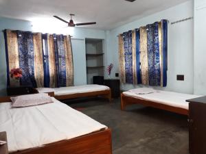 kolkataPushpak Guest House Boys, Near DumDum metro Station的带三张床和天花板的客房