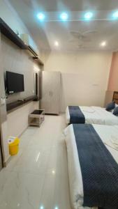 瓦拉纳西Goroomgo Prakash Residency Varanasi Near Kashi Vishwanath Temple的酒店客房设有两张床和一台平面电视。