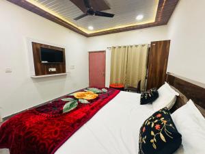 AyodhyaGoroomgo Ram Krishna Palace Ayodhya - Luxury Room - Top Rated and Most Awarded Hotel in Ayodhya - Best Seller的一间卧室配有一张床铺,床上铺有红色毯子