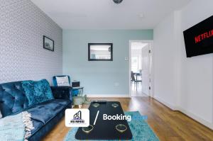 曼彻斯特4 Bedroom House Free Parking By NYOS PROPERTIES Short Lets & Serviced Accommodation Manchester的客厅配有蓝色的沙发和桌子