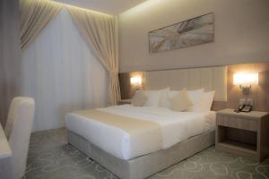 吉达فندق نارس بلس النزهة - Nars Plus Hotel的卧室配有一张白色大床和两盏灯。