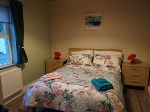 利默里克Pegs Cottage的一间卧室配有一张带花卉床罩的床