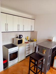 布尔奇科Venus Apartman的厨房配有白色橱柜和炉灶烤箱。