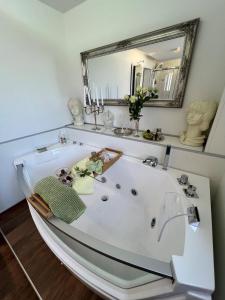 哈布凯恩Engel Ingold Lodge Chalet "Bärgblümli"的浴室设有白色浴缸及镜子