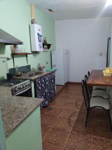 特尔马斯德里奥翁多yusulpayki的厨房配有炉灶、桌子和冰箱。
