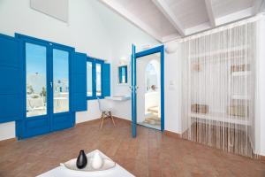 卡马利Seaside by Manos的浴室配有蓝色门、浴缸和水槽