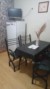 门多萨Departamentos Avenida San Martin的一张桌子和椅子、一张黑桌子和一台冰箱