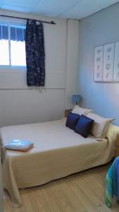 门多萨Departamentos Avenida San Martin的一间卧室配有一张带蓝色枕头的大床