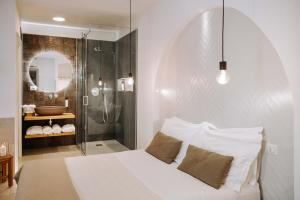 莫诺波利Dirium - exclusive rooms的卧室配有白色的床和淋浴