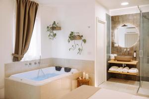 莫诺波利Dirium - exclusive rooms的带浴缸和镜子的浴室