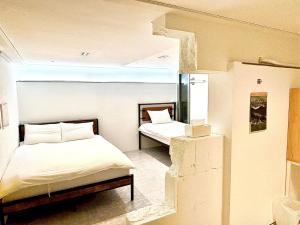首尔Look Home Guesthouse的一间卧室设有两张床,其中设有窗户。