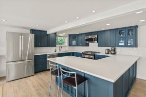 LivoniaLuxury Conesus Lakeside Dock Modern Amenities的厨房配有蓝色橱柜和白色台面