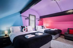BalbySocial Media Adventure - 3 Bedroom - City Centre - Doncaster的一间设有两张床和紫色墙壁的客房