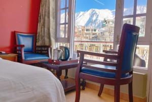 达兰萨拉Hotel Snow Crest Inn - Natural landscape Mountain View的山景卧室 - 带2把椅子