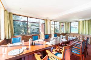 达兰萨拉Hotel Snow Crest Inn - Natural landscape Mountain View的大型用餐室配有长桌和椅子