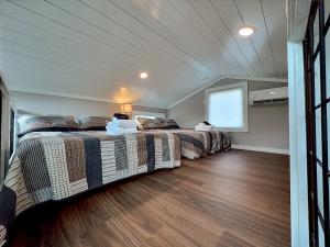 海厄沃西Retreat on the Lake的配有2张床的木地板客房