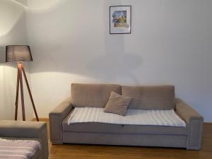 米特罗维察Boulevard Mitrovica的客厅里配有带枕头的沙发