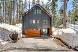 Soda SpringsLuxe Soda Springs Cabin Hot Tub, Forest-View Deck的雪中树林里的一个小小屋