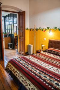 奥塔瓦洛Hostal Riviera Sucre的一间卧室设有一张黄色墙壁的大床